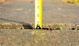 Measuring tape on cracked concrete before PolyRenewal injection