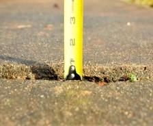 Measuring tape on cracked concrete before PolyRenewal injection