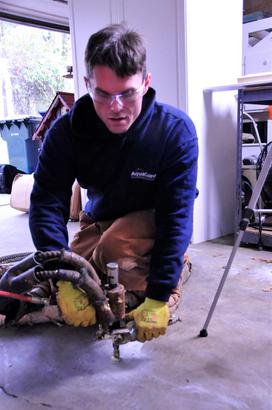 Man injecting PolyRenewal foam into garage floor