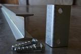 A metal I beam with bracket and two screws