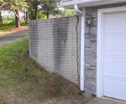 Cracked retaining wall next to garage door