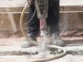 A featured image of an Aquaguard Employee repairing a concrete slab drilling into the foundation.