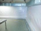 Clean and bright basement corner with white insulated walls and a concrete floor.