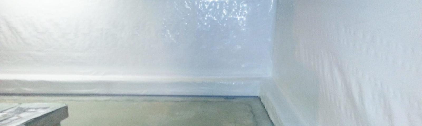 Clean and bright basement corner with white insulated walls and a concrete floor.