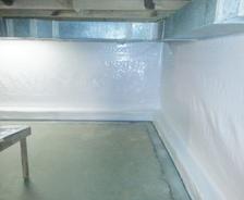 Clean and bright basement corner with white insulated walls and a concrete floor.