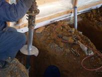 Aquaguard Foundations crew member installing helical piers.