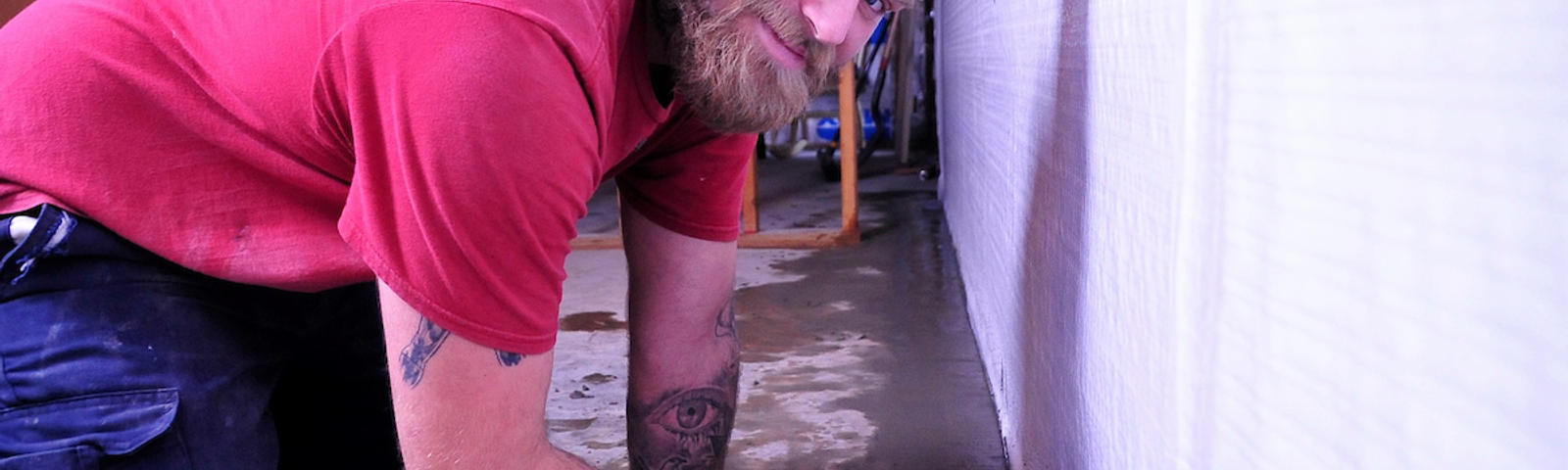 a worker installs a basementgutter around perimeter