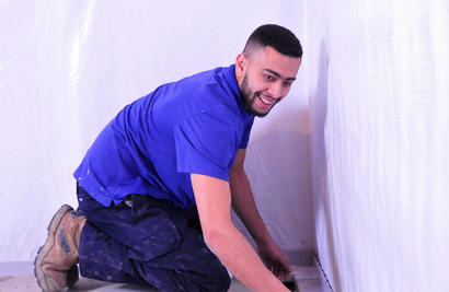 Worker installing basement drainage