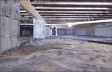 Crawlspace before encapsulation with exposed cinder block columns