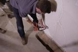 Crew member sealing basement walls from water seepage