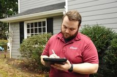 Certified Field Inspector taking notes outside a homeowners house