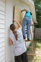 two men boarding up windows