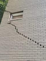 large exterior brick crack that extends to a second floor, indicating foundation damage
