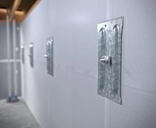 Basement wall anchors mounted in a newly waterproofed basement