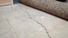 Slab foundation crack with carpet rolled up