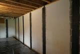 Carbon fiber wall reinforcement in place on the interior of a basement wall