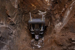 A professional push pier in the process of being installed at the foundation of a home