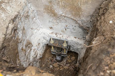 The footing of of a push pier in place at the foundation of a home