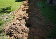 Exterior holes dug as ports for interior basement wall anchors