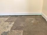 Floor and wall gap due to uneven floor and foundation settlement illustrated by a laser level in the corner of a house
