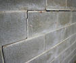 Cracked concrete blocks in a masonry wall, showing signs of structural damage.