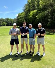 AquaGuard emplotees pose with golf clubs on a sunny golf course, trees and blue sky in the background. pose with golf clubs on a sunny golf course, trees and blue sky in the background.
