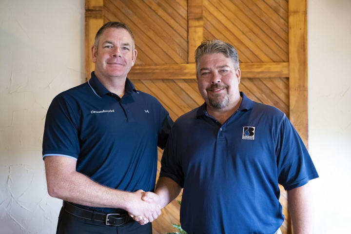 Matt Malone shaking hands with Baker's Waterproofing Owner; Jake Waltz