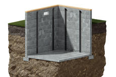Cross-section of a basement corner with concrete walls and floor, supported by metal braces in soil.