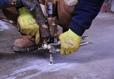 AFS crew member conducting a PolyRenewal injection into concrete slab.