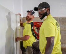 workers installing vapor barrier in basement