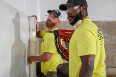 workers installing vapor barrier in basement