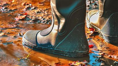 Basement flooding example with somone standing in a puddle wearing boots.