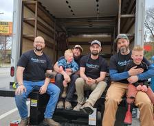 AFS crew members and family smiling while sitting in AFS truck.