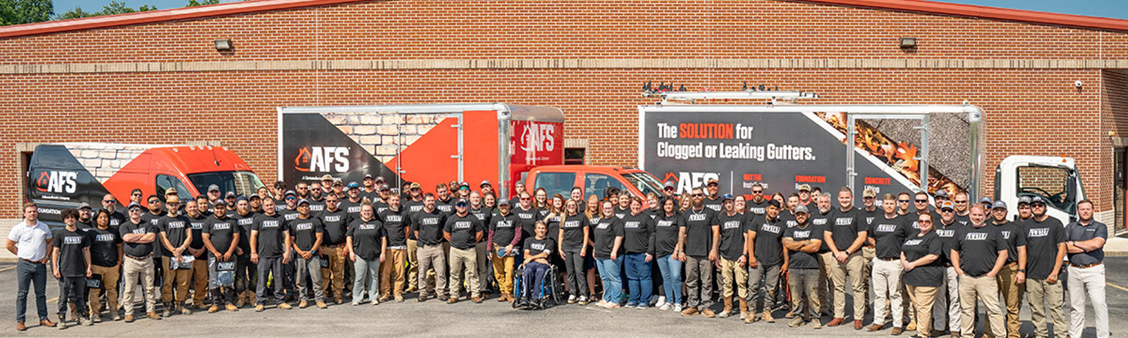 AFS employees standing in front of building and box trucks