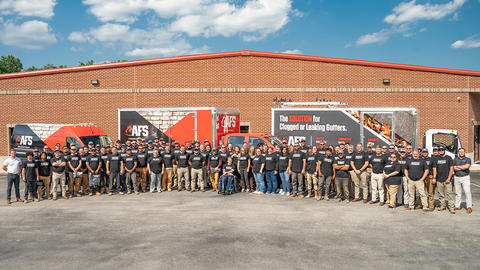 AFS employees standing in front of building and box trucks