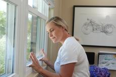 woman trying to open sticking window