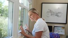 woman trying to open sticking window