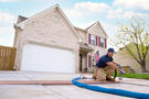 worker repairing concrete driveway by leveling