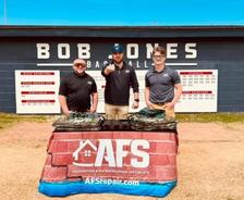 AFS staff stands at table in front of Bob Jones high school