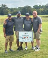 Four AFS crew members on golf field at RMHC golf tournament