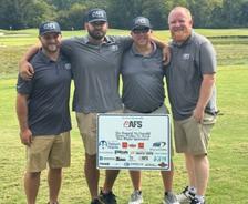 Four AFS crew members on golf field at RMHC golf tournament
