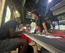 man signing autograph for a fan at the Louisville Bats activation