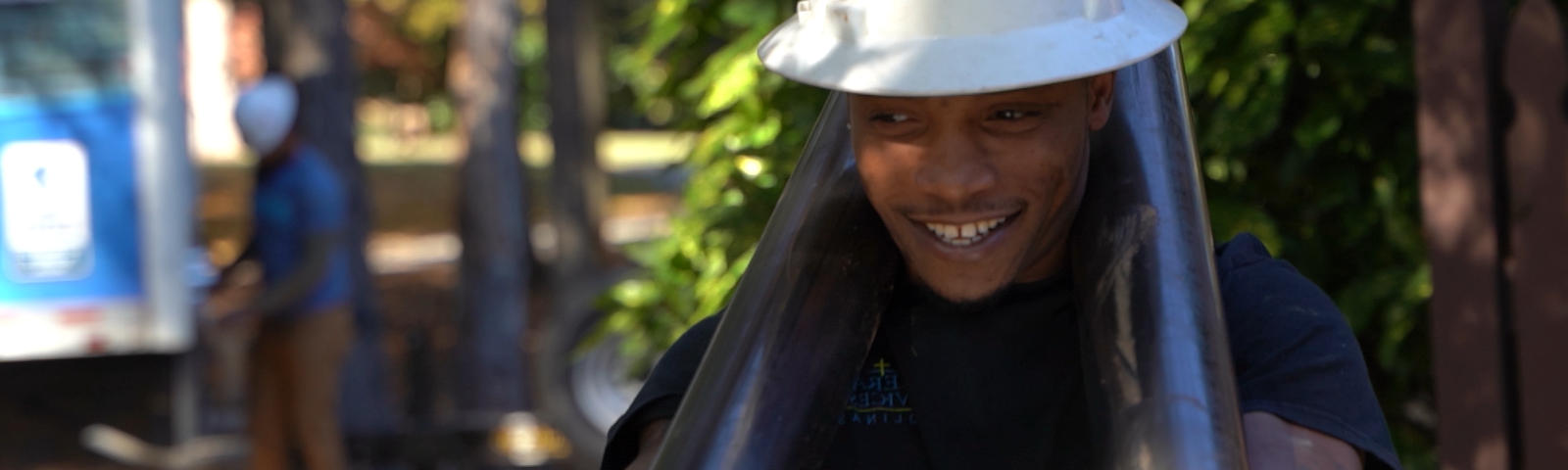 Foundation Systems of Michigan crew member carrying push piers while smiling.