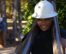 Foundation Systems of Michigan crew member carrying push piers while smiling.