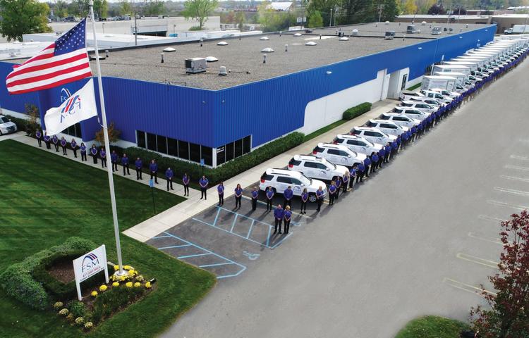Foundation Systems of Michigan employees standing in a line in front of FSM building.