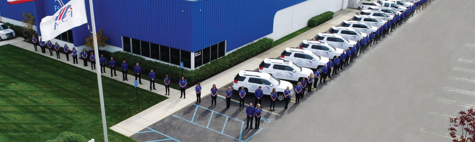 Foundation Systems of Michigan employees standing in a line in front of FSM building.