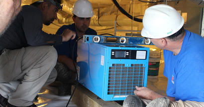 FSM crew members installing dehumidifier.