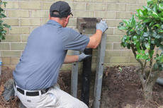 FSM Crew member installing piers to brick home.