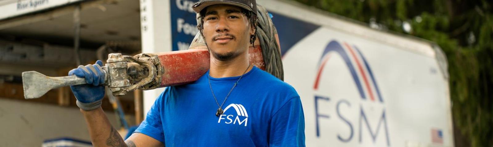 FSM crew member holding jackhammer.