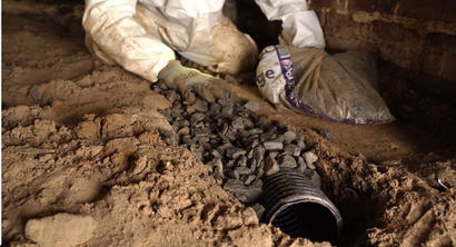 CFI installing a drainage pipe within a crawl